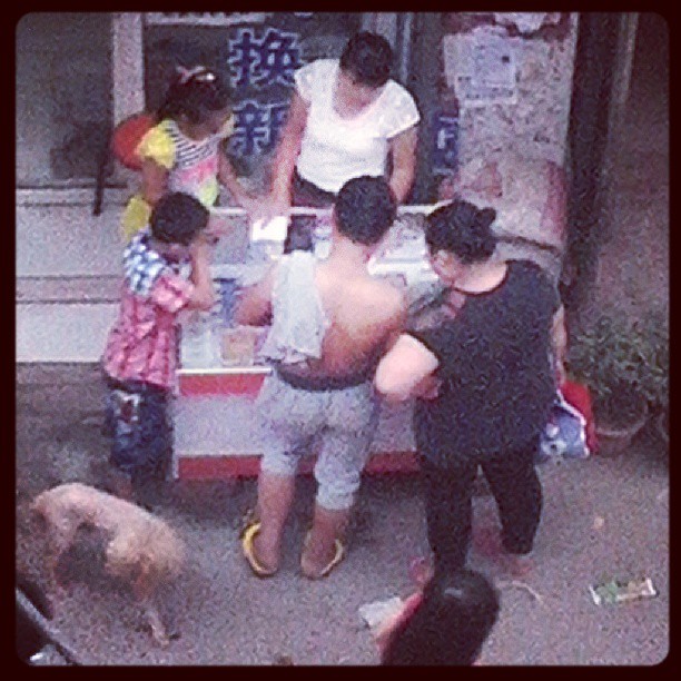 2013/07/22 — 我家楼下街上一个女人在卖刮刮奖，买的人还不少（文琼今天下午在出租房的三楼拍的街上）
