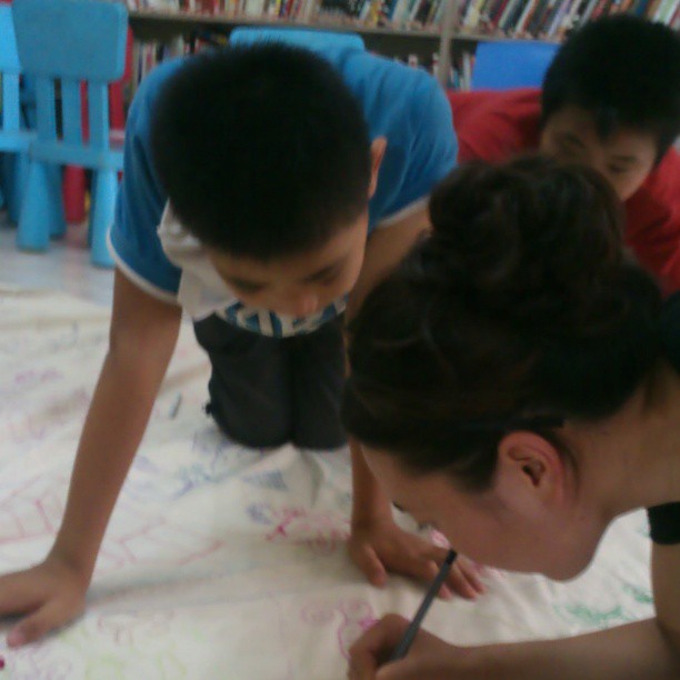 2013/07/14 — 志愿者在和夏令营的孩子一起画社区地图。(美霞摄)