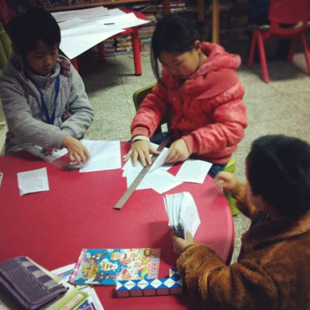 2013/02/04 — 孩子们正在裁打工春晚的宣传单，下午我们要一起去做宣传，这也是年前的最后一次宣传