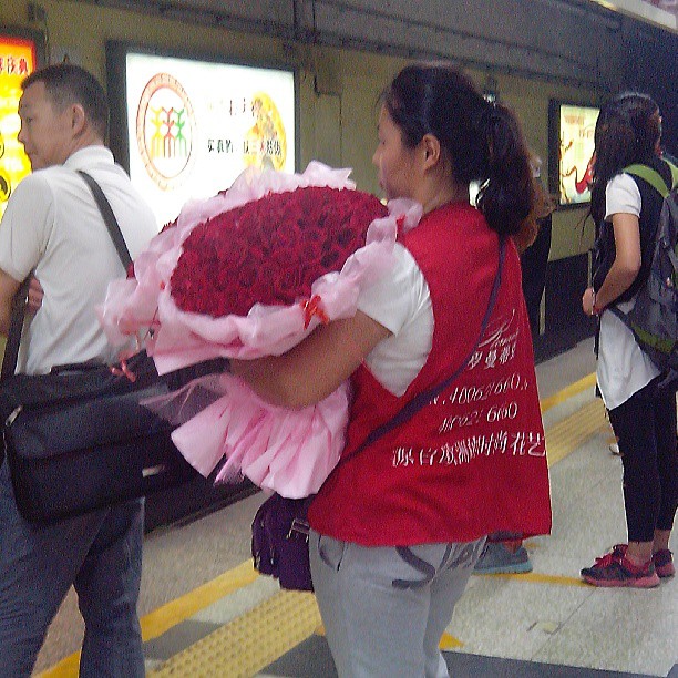 2013/08/12 — 一位二十来岁的小姑娘，抱一大抱花，在地铁站等车，引起了很多人的注意，马上就七夕节到了！