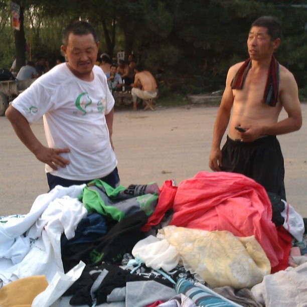 2013/07/10 — 工人边看衣服，边询问去长城的路线，"哪天有空了也去逛逛"一—木兰美霞摄